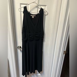 Black cocktail dress. Detail at waist and ties at shoulder.